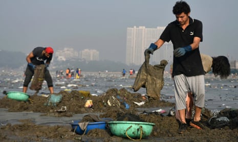 Workers and volunteers help clean up Versova beach in Mumbai, India