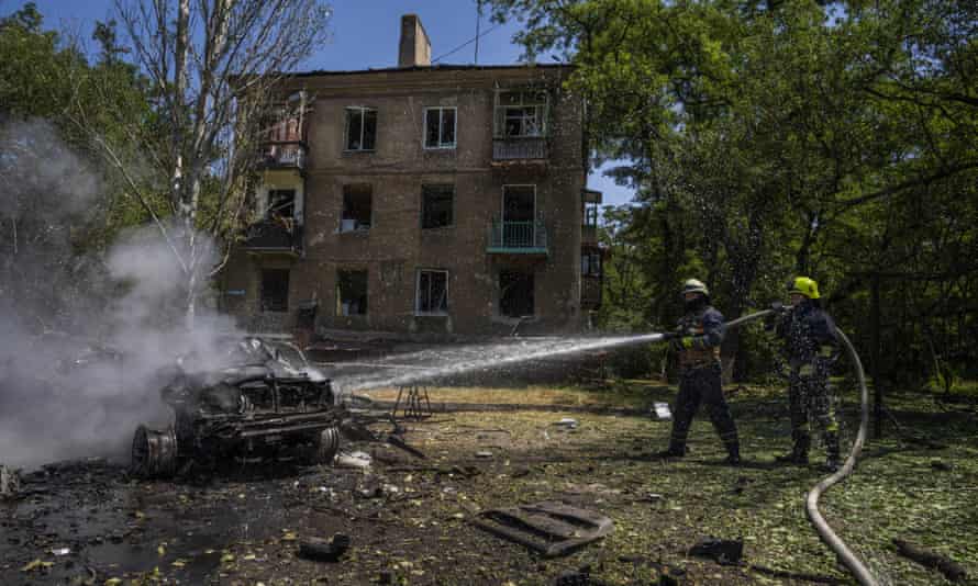 Firefighters hose down a burning car after an airstrike hit a residential area in Kramatorsk.