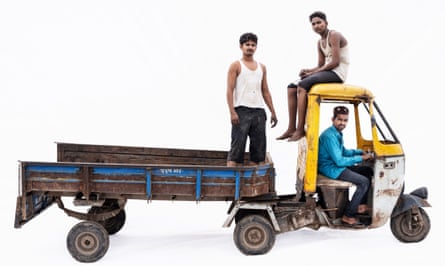 Couriers Mohammad, Mohammad and Sabir in a Bajaj truck in Malegaon, Maharashtra, India. It is an open-backed truck and one of them sits in the cab, another on top of it and one stands in the back