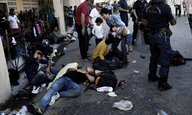 People try to recover after clashes with the police during a protest at the Lesvos Port