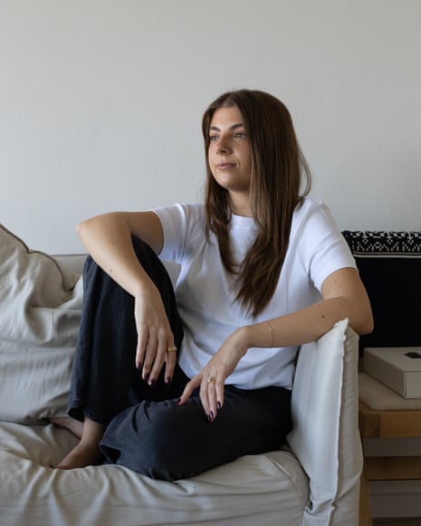 Maddy Mavrikis in her Sydney apartment, relaxing on a beige sofa