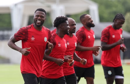 Chancel Mbemba (left) smiles while running with teammates during training