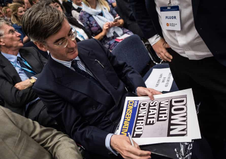 Jacob Rees-Mogg signs a poster that reads ‘Down with state control’ at the Tory conference.