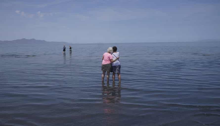 Visitors stand in the shallow waters of the Great Salt Lake.