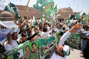 People hold national flags and throw flower petals in the air