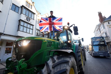 A tractor in an Oxford street with a man holding a union jack