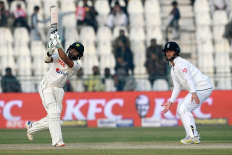 Saud Shakeel lofts a shot as Ben Duckett looks on.