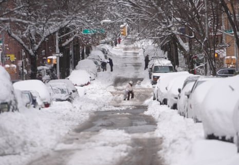 People shovel snow on a Long Island City street buried under heavy snowfall from a blizzard