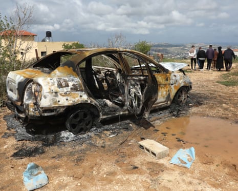 Palestinians inspect a burned vehicle after an attack by Jewish settlers on farmers’ property in the West Bank village of Fandaqamiya in March