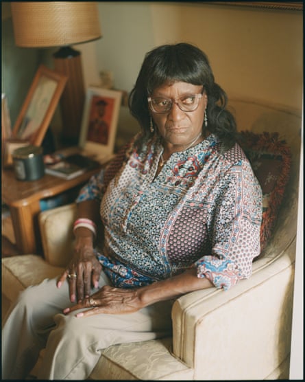 An older woman sits on an easy chair.