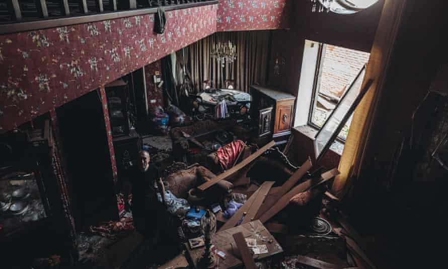 A man tries to collect usable wares from his house which was destroyed by Russian attacks on Kharkiv.