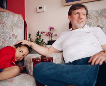 David, sitting in an armchair, strokes Macsen’s head as the boy lays on another chair alongside