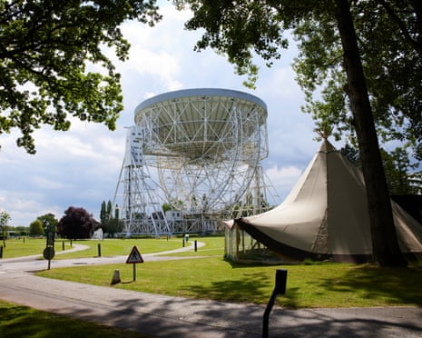 The Lovell Telescope at Jodrell Bank stands on a green lawn beside a white curved structure
