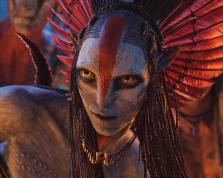 A strange creature with a fringed headdress and a gold necklace. It has a white face with a red stripe down to its nose