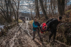 Hasan’s son-in-law helps him to carry baby Darya in her pram near the Croatian border.