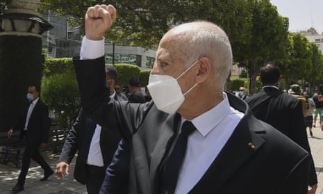 Tunisia’s president, Kais Saied, raises his fist to bystanders in Tunis.