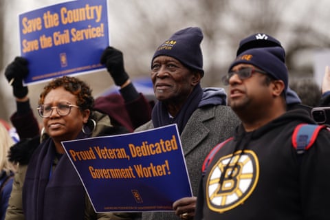 people hold placards at a rally