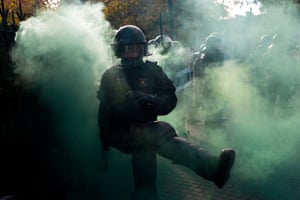 A member of the Catalan regional police force kicks away a smoke bomb.