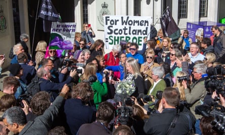 Two women raise glasses amid a crowd of their fellow campaigners