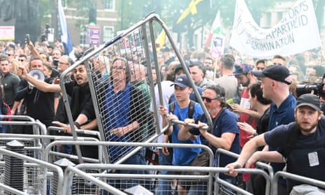 People throw fencing during an anti-vaccine and anti-lockdown demonstration outside Downing Street.