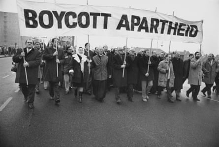 people hold a banner that reads ‘boycott apartheid’