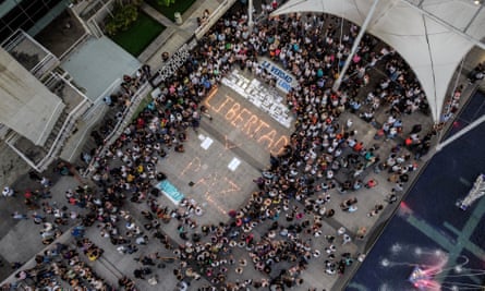 Aerial shot of a crowd surrounding candles spelling out “Libertad y paz.”