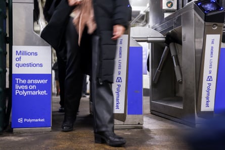 ads for Polymarket on subway turnstiles as person walks through