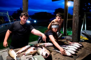 Howard, his sister Juliette and their cousin Reggie clean the red and drum fish they caught earlier