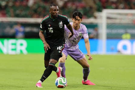 Julián Quiñones, wearing a achromatic jersey and shorts, dribbles against a South Korea defender successful their World Cup match.