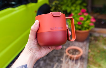 A hand holds a red Klean Kanteen Rise Mug