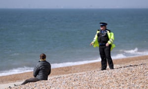 A PCSO talks to a member of the public on Brighton beach