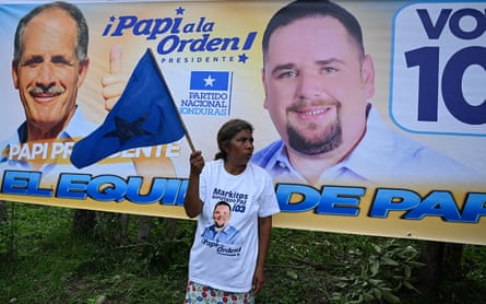 A supporter of Honduran presidential candidate Nasry Asfura holds a flag during a rally in Macuelizo, Honduras on 13 November.