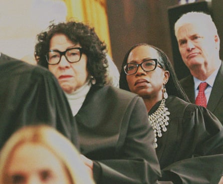 A supreme court justice stands behind other justices
