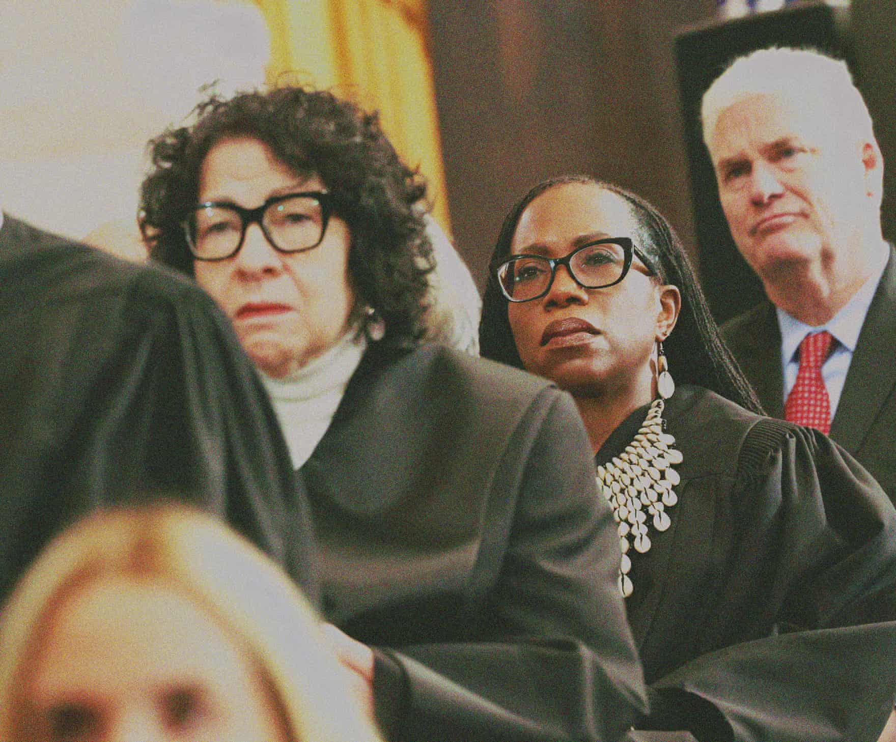 A supreme court justice stands behind other justices