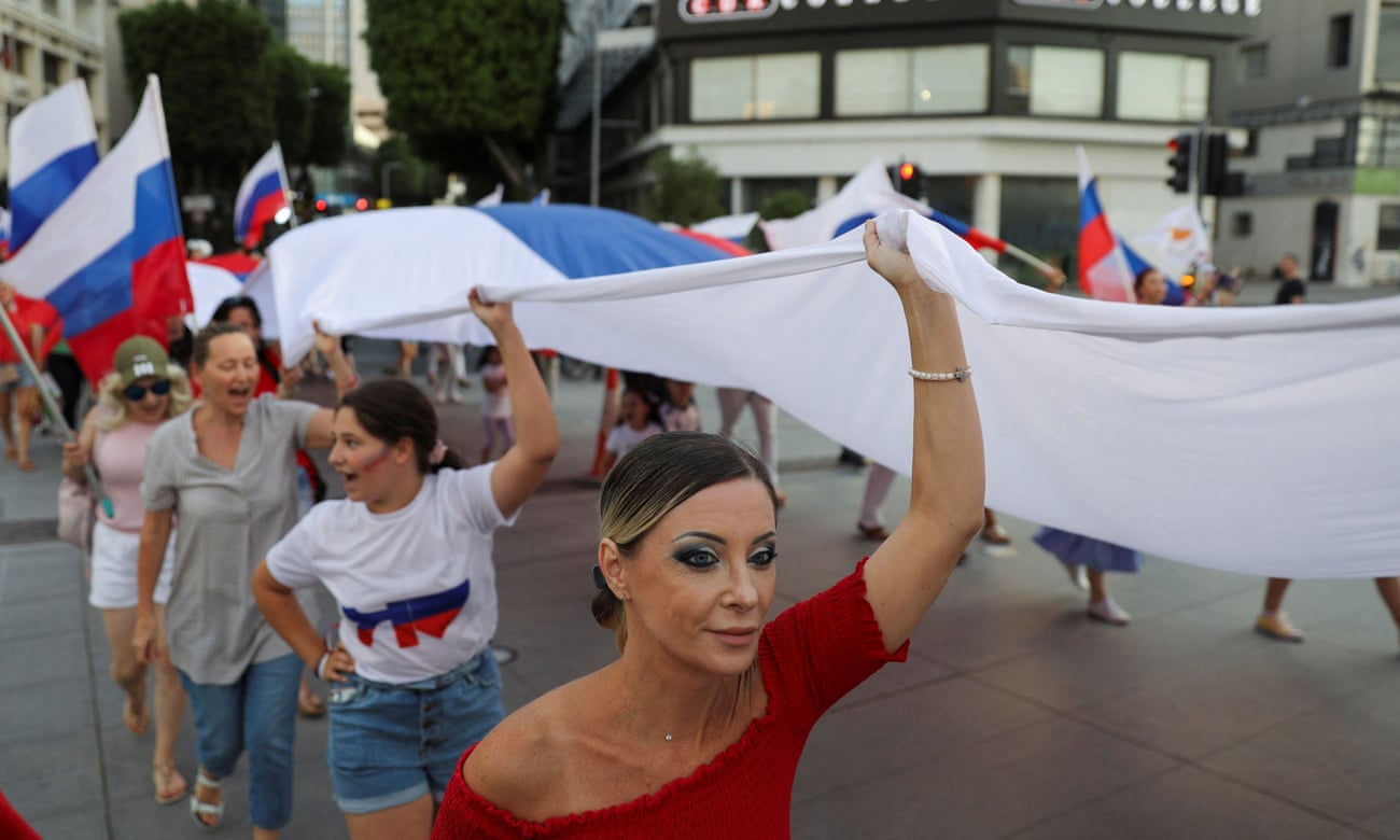 Russia Day celebrations in Nicosia, women parade with Russian flag