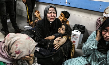 Wounded Palestinians sit in al-Shifa hospital in Gaza City, central Gaza Strip, after arriving from al-Ahli al-Arabi hospital following an explosion there, Tuesday, 17 October, 2023.