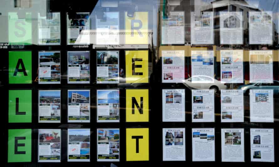 Houses for sale and lease are advertised in the window of a real estate agent