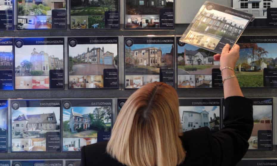 A woman looking at houses for sale at an estate agent