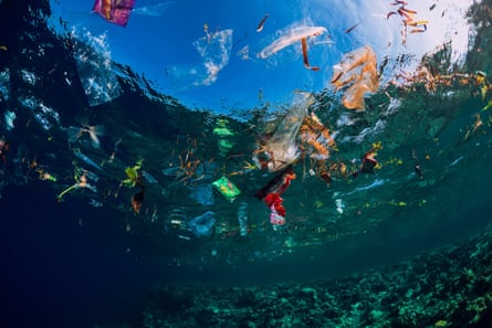 An underwater picture of ocean water full of plastic pieces and bags.