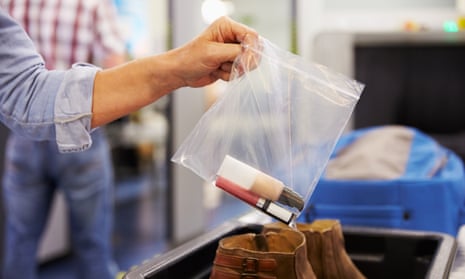 A passenger puts liquids into a bag at airport security check