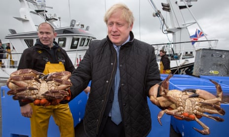 Prime minister Boris Johnson holds crabs caught on the Carvela with Karl Adamson at Stromness harbour in Scotland.