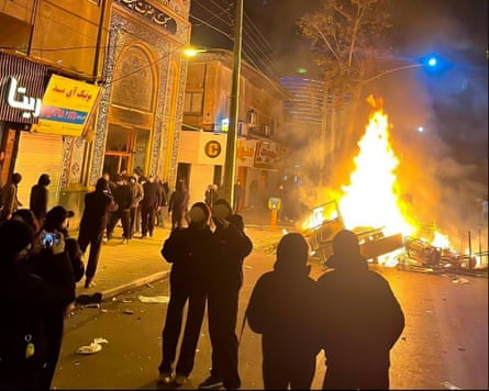 Demonstrators next to burning debris in Gorgan.