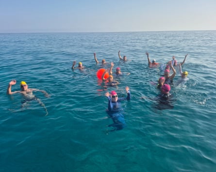 Open-water swimmers waving to the camera