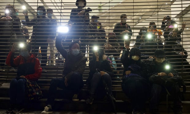 Pro-democracy protesters hold mobile phone lights in the air outside court in Hong Kong