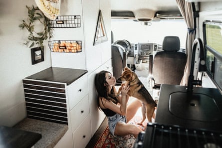 young woman and dog inside sprinter van with living area