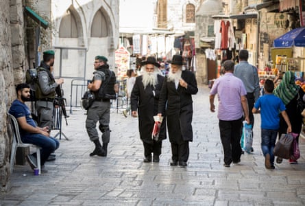 Orthodox Jews pass Israeli Defence Forces soldiers in the Muslim Quarter of the Old City