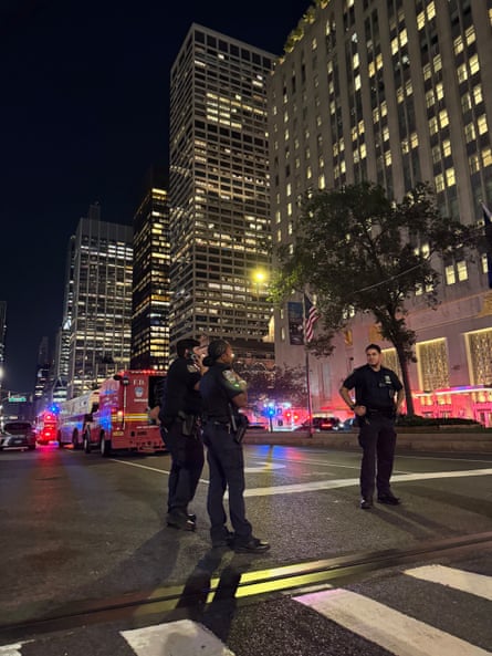 three people in uniform stand on city street