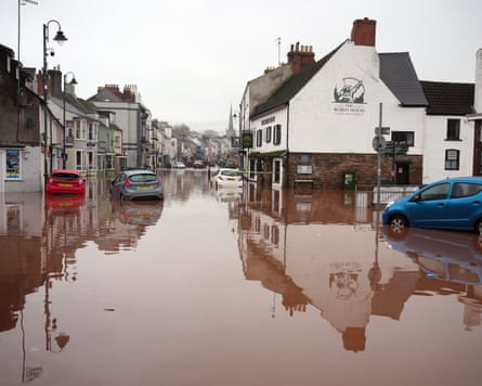 Village high street with several cars partly submerged in water