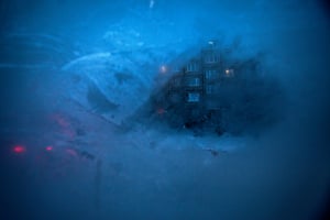 An apartment block is seen through a layer of ice on the window of a passenger minibus in the outskirts of Murmansk