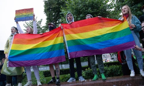 Protesters hold rainbow flags